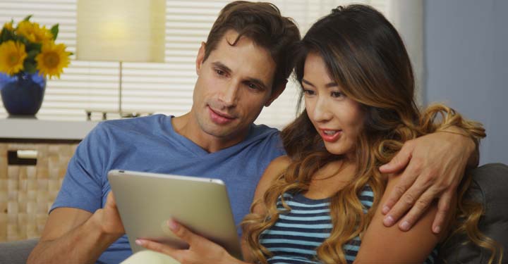 Pareja sostiene iPad en su sofá