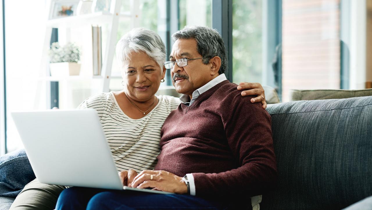 Pareja mayor aprende a hacer testamento en una laptop