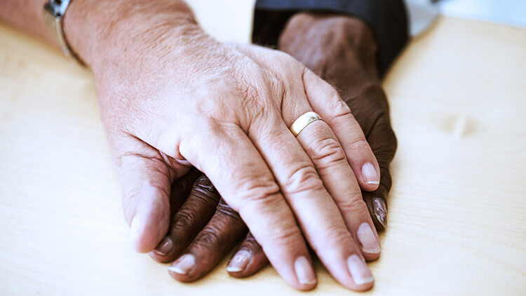 manos de pareja de edad con alianzas de boda