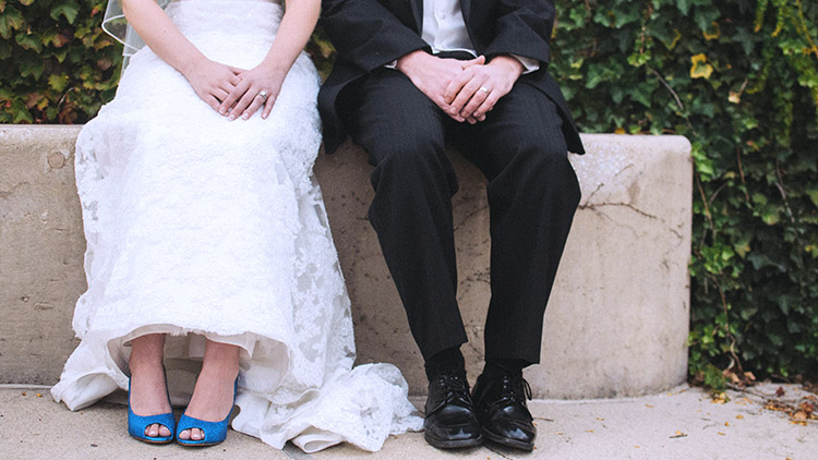 La novia y el novio se sientan uno al lado del otro con ropa de boda
