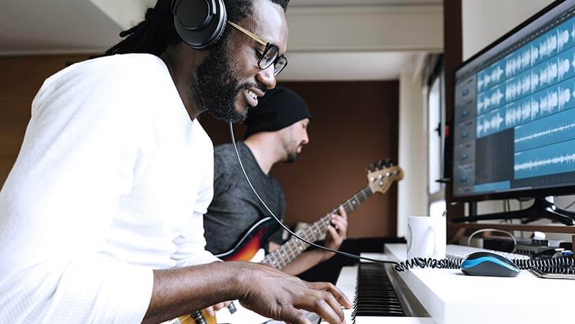 músico-tocando-guitarra-y-piano-grabando-mezclando-sonido