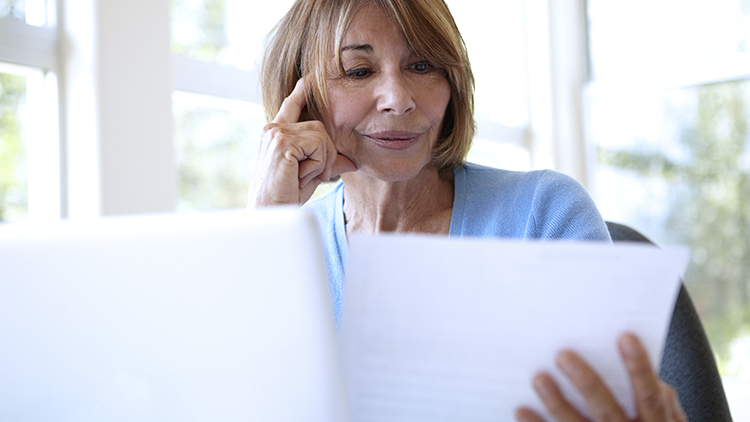 Mujer mayor mira documentos