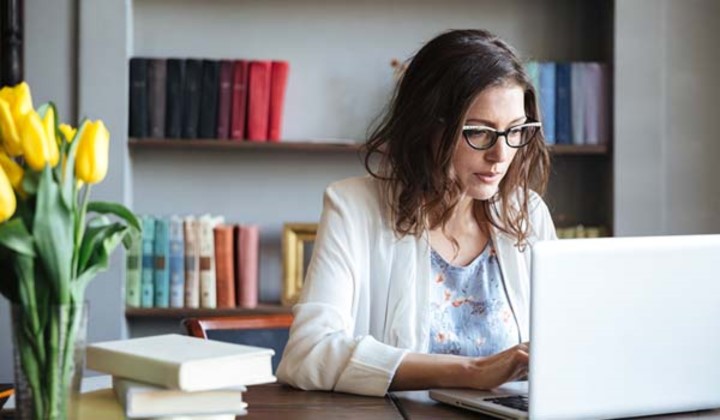 Mujer escribiendo en la computadora portátil