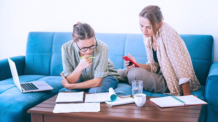 Dos mujeres mirando documentos en casa